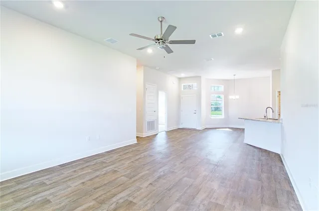 an empty room with a ceiling fan and carpet