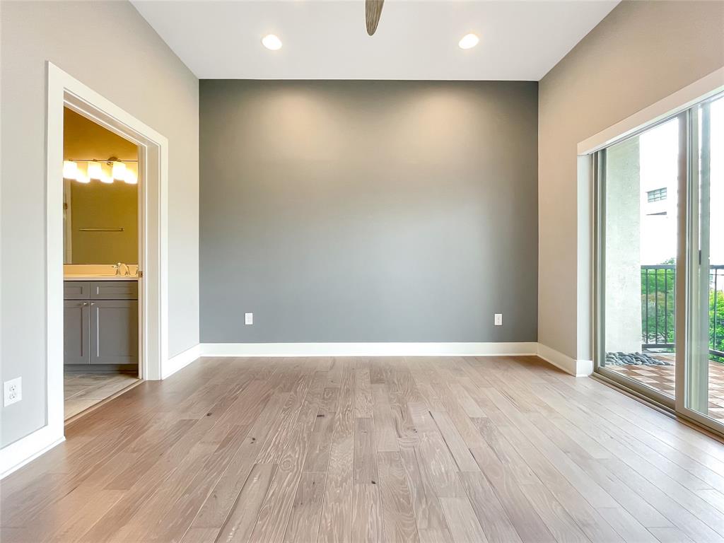908 Nueces Street, Unit 42 Austin, TX 78701 - Photo 13 of 21 a view of an empty room with wooden floor and a window