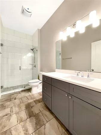 a spacious bathroom with a bathtub shower sink mirror and toilet