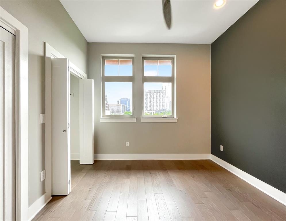 908 Nueces Street, Unit 42 Austin, TX 78701 - Photo 17 of 21 an empty room with wooden floor and windows