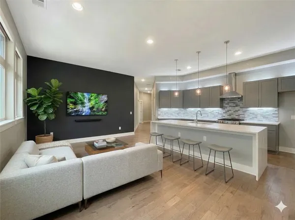 a living room with stainless steel appliances kitchen island granite countertop furniture and a flat screen tv