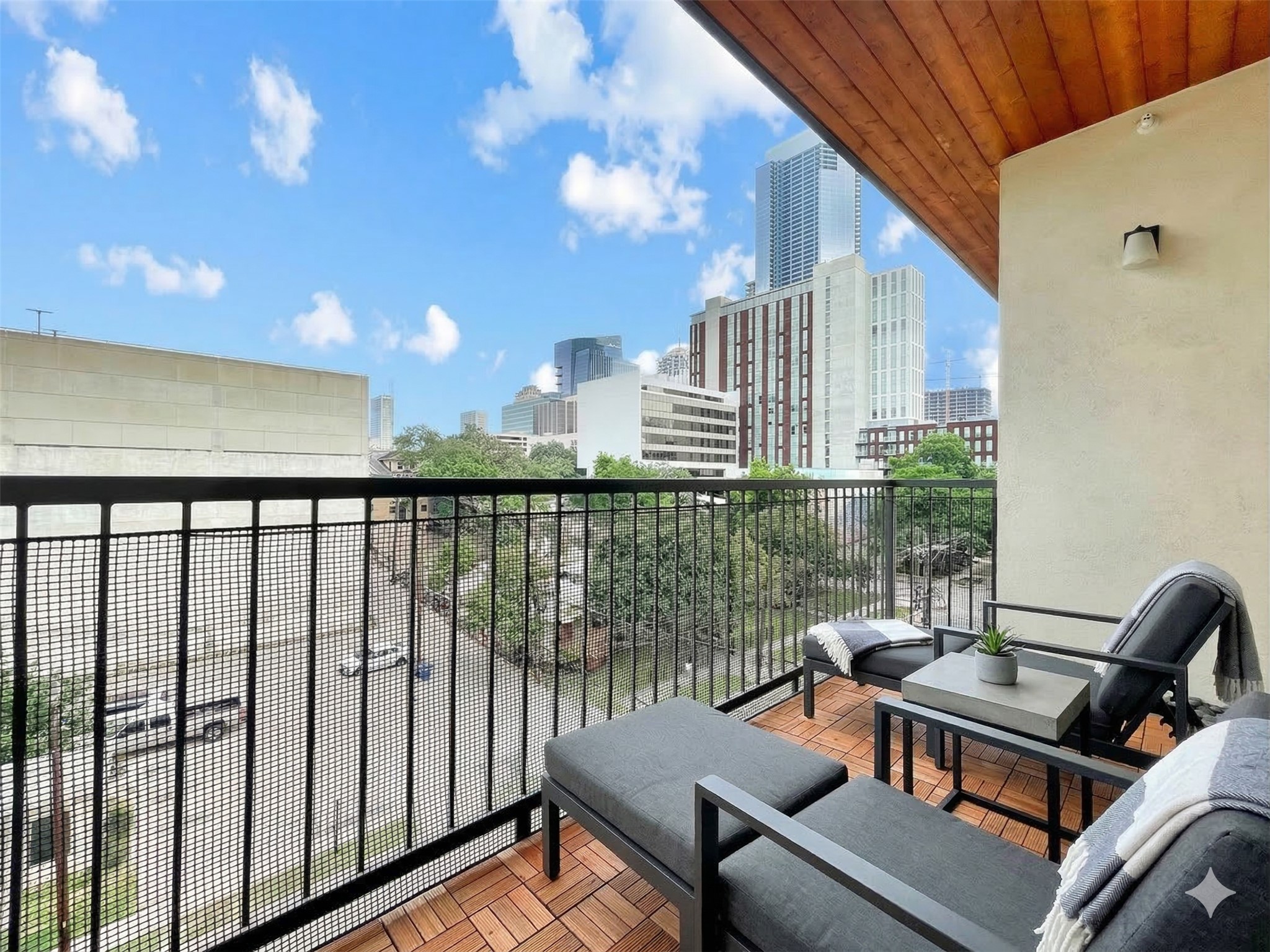 908 Nueces Street, Unit 42 Austin, TX 78701 - Photo 4 of 21 a view of a balcony with wooden floor and outdoor seating