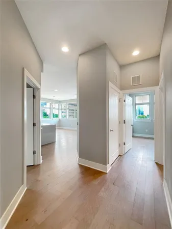 a view of a hallway with wooden floor and a kitchen