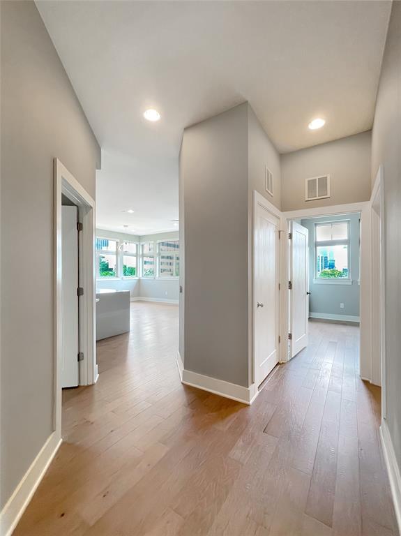 908 Nueces Street, Unit 42 Austin, TX 78701 - Photo 5 of 21 a view of a hallway with wooden floor and a kitchen
