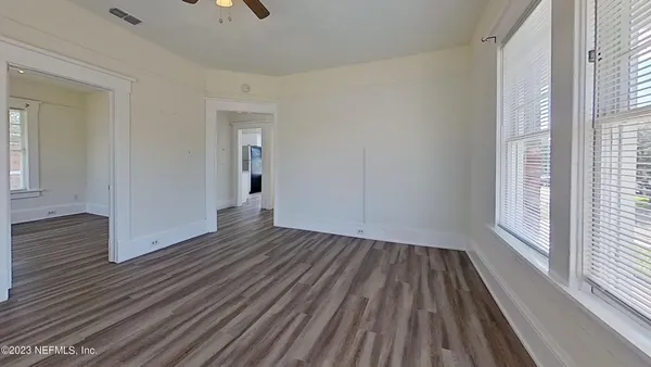 a view of a room with wooden floor and window