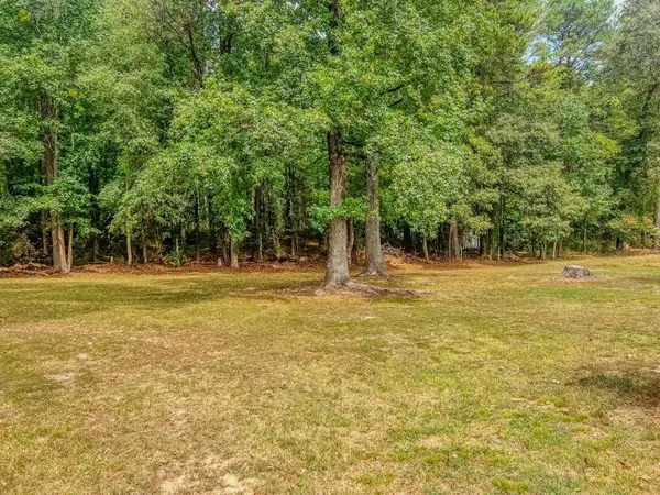 a white house with a yard and large trees