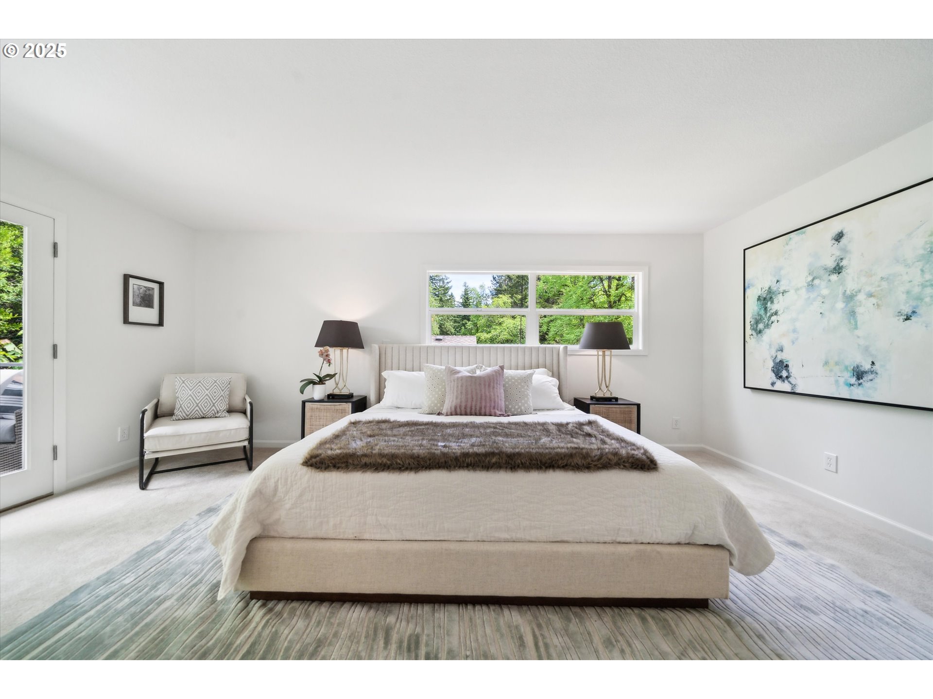 0501 South Riverside Street Portland, OR 97219 - Photo 22 of 45 a spacious bedroom with a bed a couch and a large window
