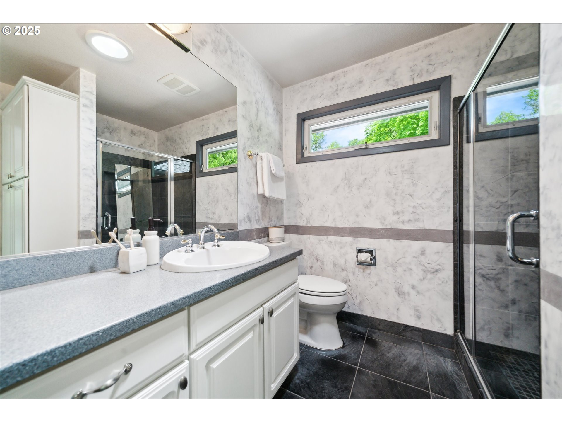 0501 South Riverside Street Portland, OR 97219 - Photo 25 of 45 a bathroom with a granite countertop sink a toilet a mirror and shower
