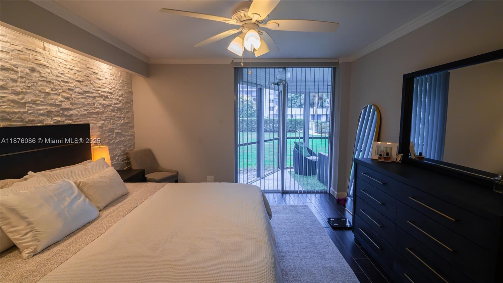 6500 Northwest 2nd Avenue, Unit 114 Boca Raton, FL 33487 - Photo 30 of 71 a bedroom with a bed and a flat tv screen on dresser