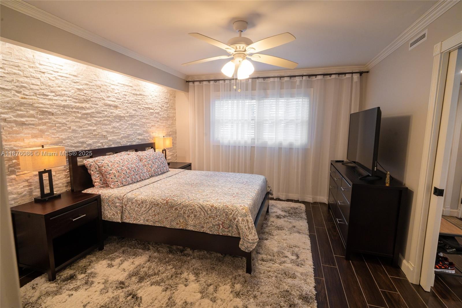 6500 Northwest 2nd Avenue, Unit 114 Boca Raton, FL 33487 - Photo 50 of 71 a bedroom with a bed and a flat tv screen on dresser