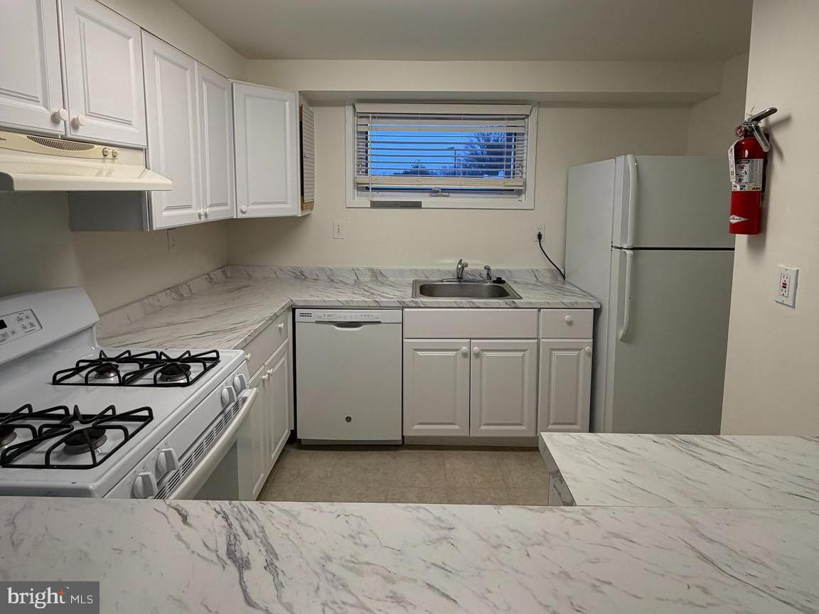 5485 Harpers Farm Road, Unit L6 Columbia, MD 21044 - Photo 6 of 20 a kitchen with a sink stove and refrigerator