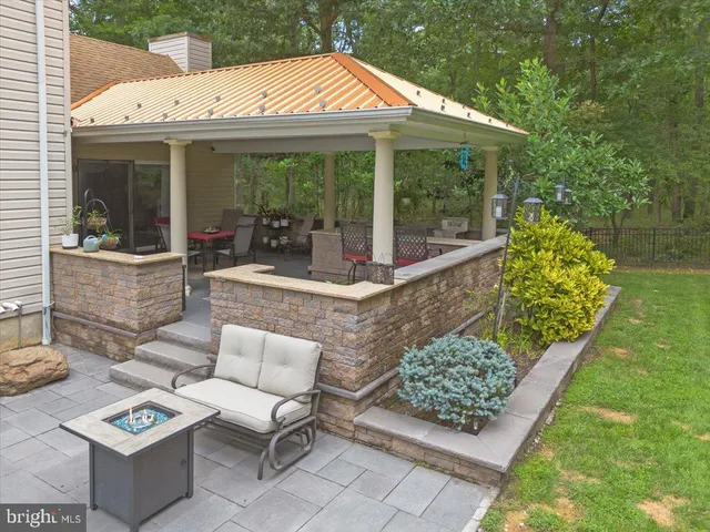 a view of a patio with a table chairs and a small yard