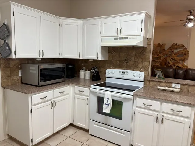 a kitchen with white cabinets and white appliances