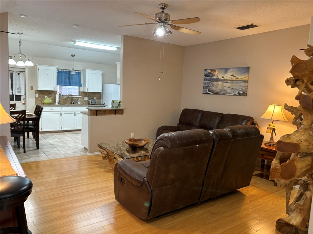 14721 Lighthouse Drive Corpus Christi, TX 78418 - Photo 6 of 17 a living room with couches and kitchen view with wooden floor