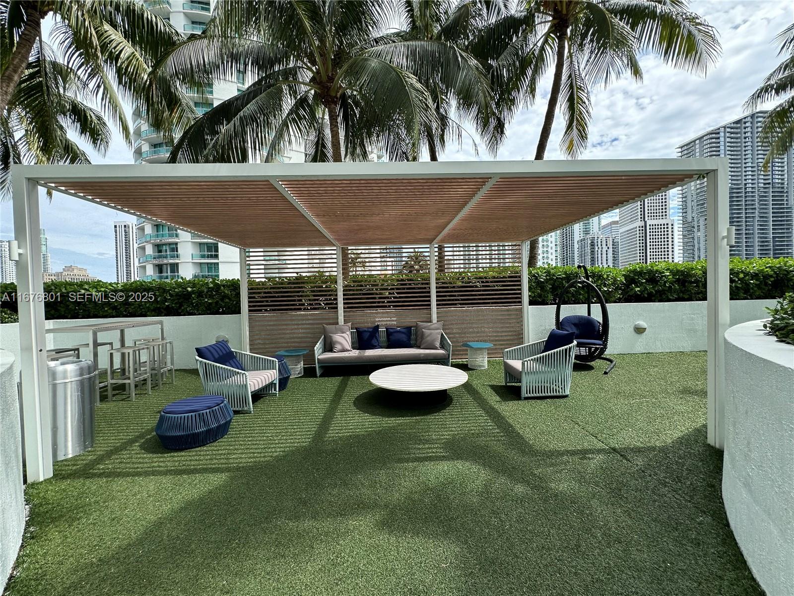 90 Southwest 3rd Street, Unit 1416 Miami, FL 33130 - Photo 11 of 31 a view of a patio with table and chairs potted plants and palm tree