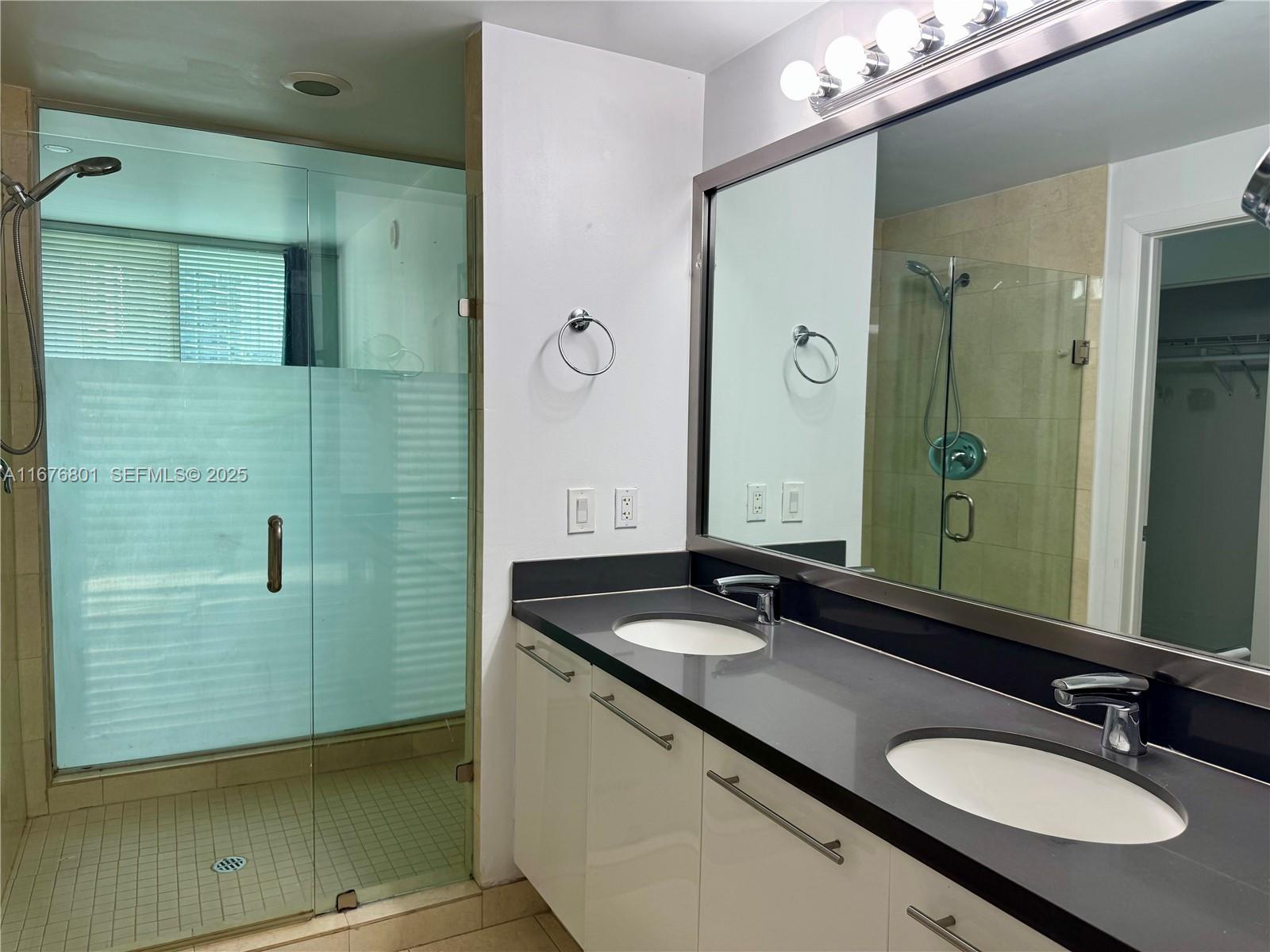 90 Southwest 3rd Street, Unit 1416 Miami, FL 33130 - Photo 23 of 31 a bathroom with a granite countertop sink and a mirror