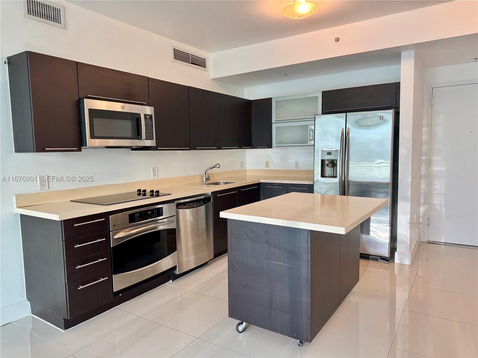 90 Southwest 3rd Street, Unit 1416 Miami, FL 33130 - Photo 6 of 31 a kitchen with a stove and a microwave