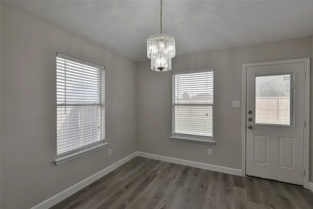 a view of a kitchen with center island stainless steel appliances wooden floor and a window