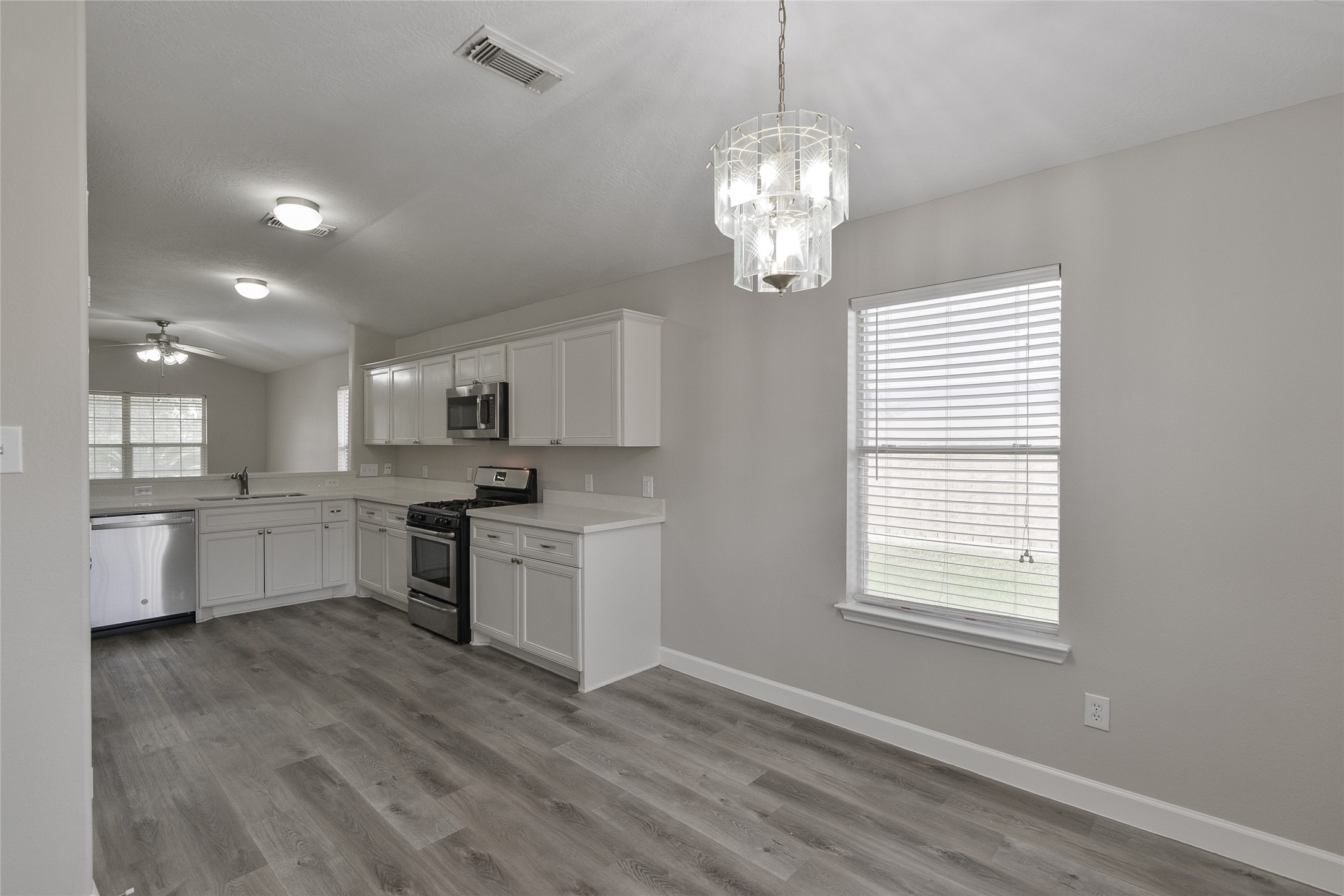 13027 Lark Point Court Houston, TX 77044 - Photo 15 of 29 a large kitchen with kitchen island white cabinets and stainless steel appliances