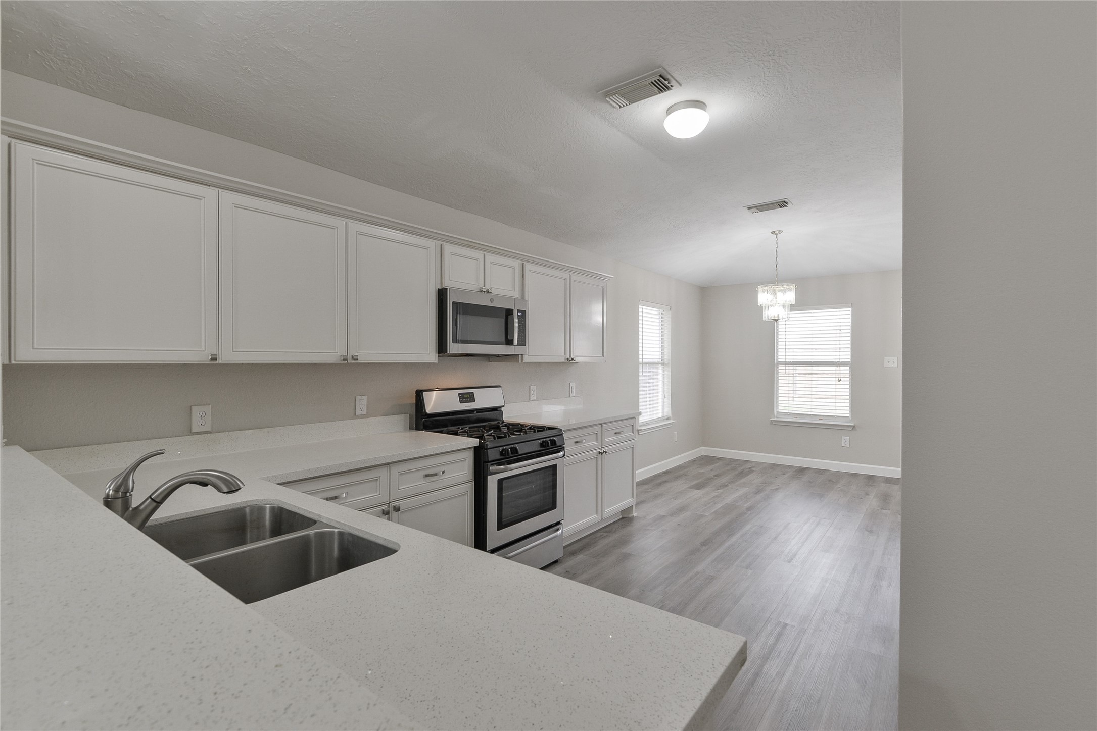 13027 Lark Point Court Houston, TX 77044 - Photo 9 of 29 a kitchen with stainless steel appliances a sink a stove a microwave a sink a refrigerator and cabinets