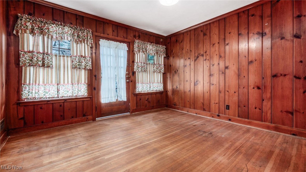 Foyer with wood walls, hardwood / wood-style flooring, and ornamental molding