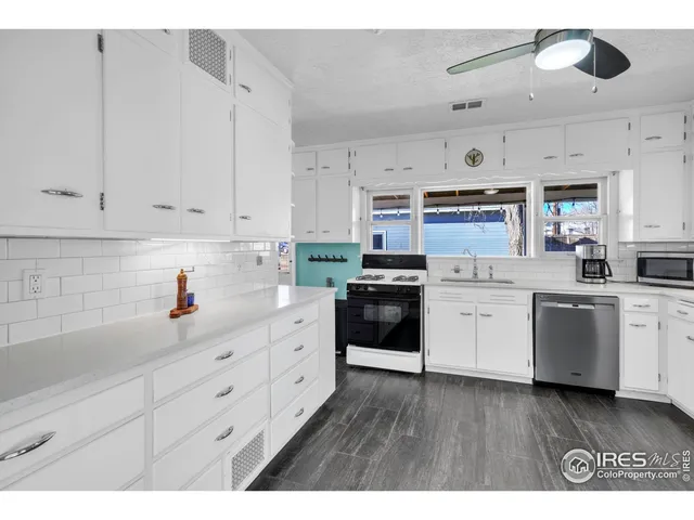 a kitchen with kitchen island white cabinets appliances and sink