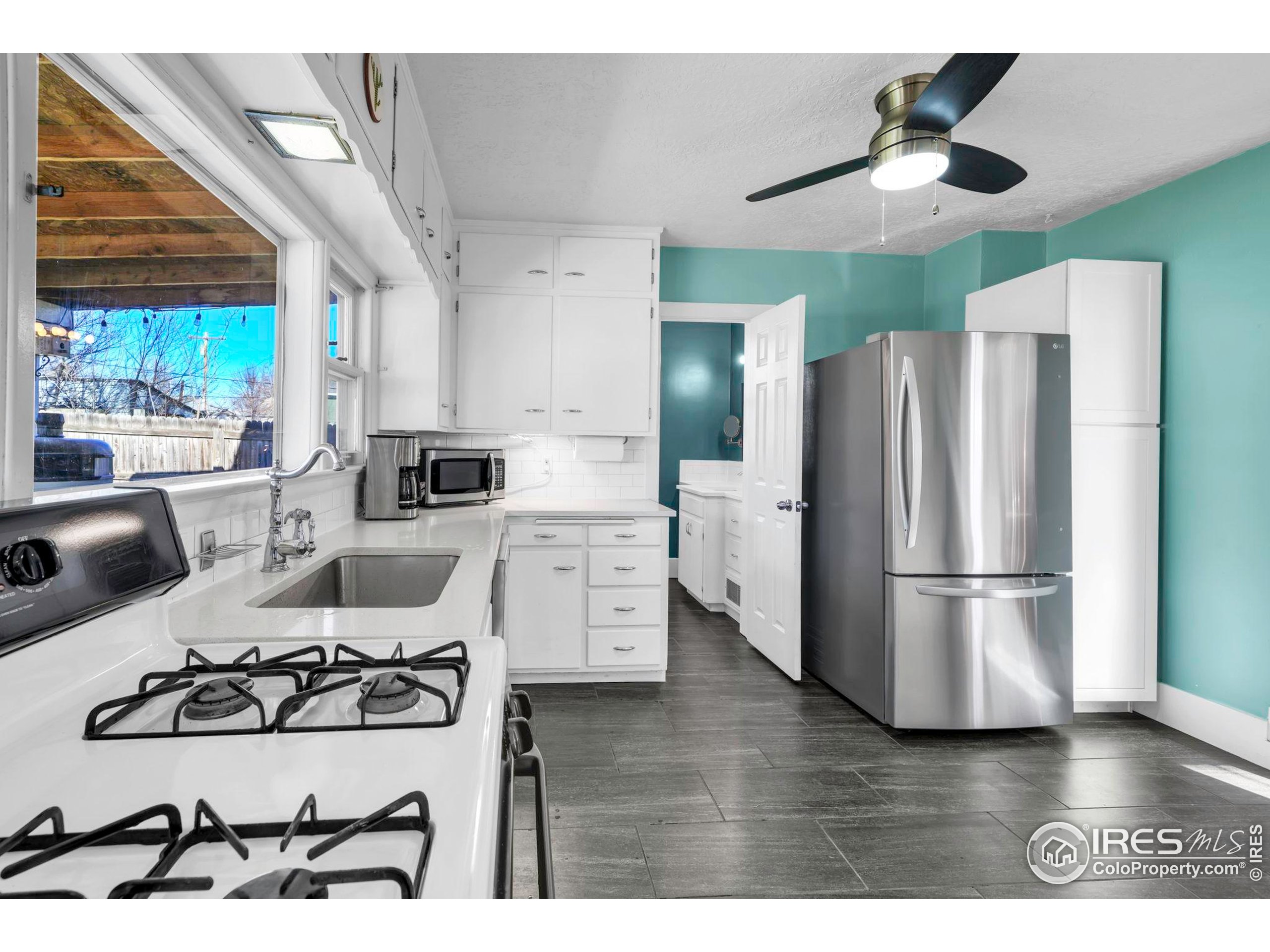 409 Main Street Mead, CO 80542 - Photo 12 of 35 a kitchen with stainless steel appliances a stove a refrigerator and a chandelier