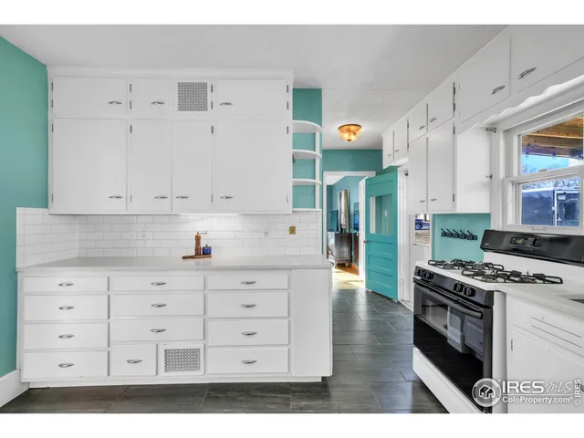 a kitchen with cabinets appliances and a wooden floor