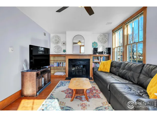a living room with furniture a flat screen tv and a fireplace