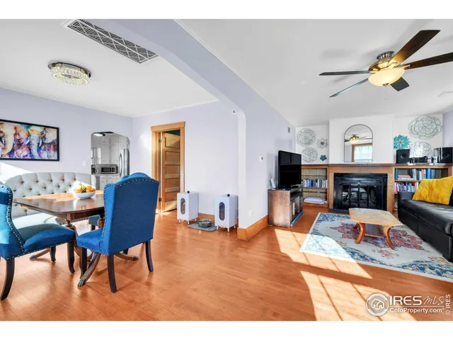 a living room with furniture a fireplace and a large window