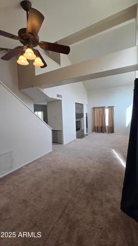 a view of a livingroom with a ceiling fan and window