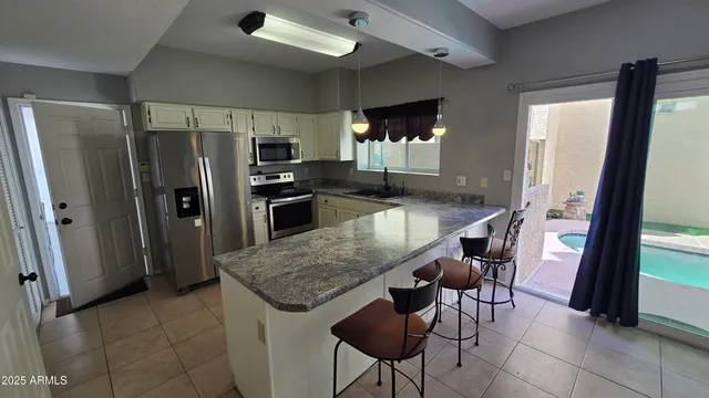 a kitchen with granite countertop kitchen island a counter space and stainless steel appliances