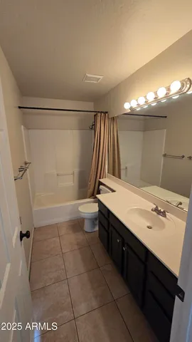 a view of an empty room and a chandelier fan