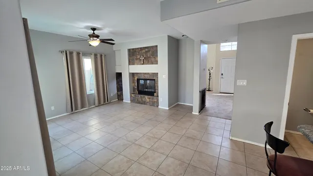 a view of a livingroom with a chandelier fan and windows