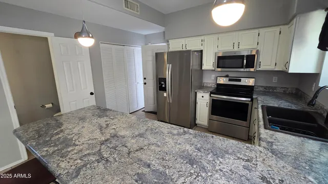 a kitchen with stainless steel appliances granite countertop a refrigerator and a sink