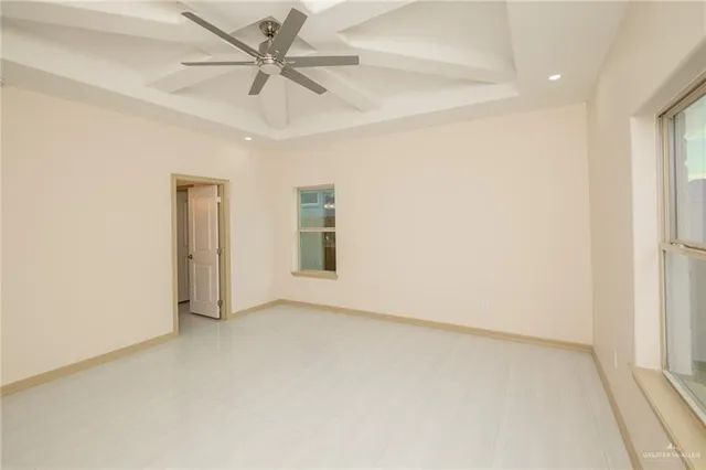 an empty room with windows and fan