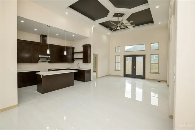 a large room with stainless steel appliances kitchen island granite countertop a sink and cabinets