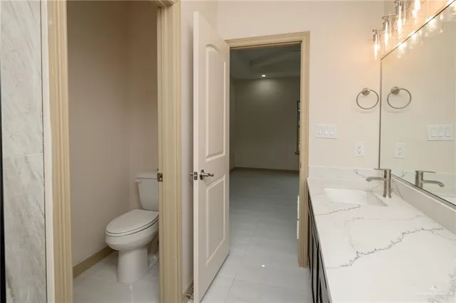 a bathroom with a granite countertop sink a toilet and shower