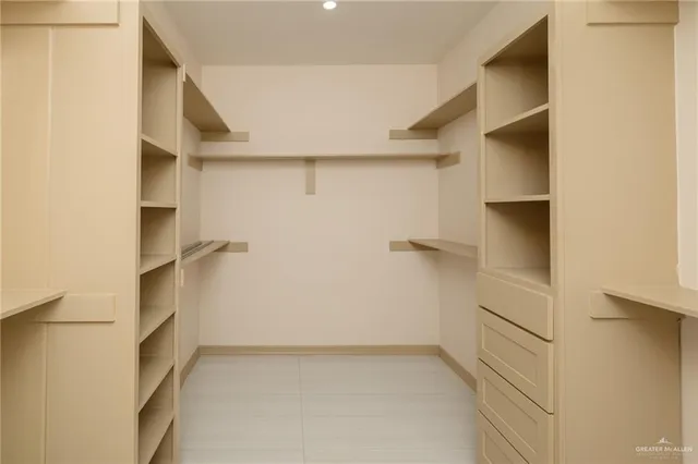 a view of walk in closet with empty racks