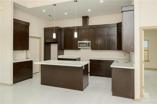 a large kitchen with stainless steel appliances kitchen island granite countertop a stove and a sink