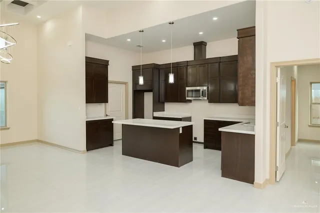 a large kitchen with stainless steel appliances a large counter top