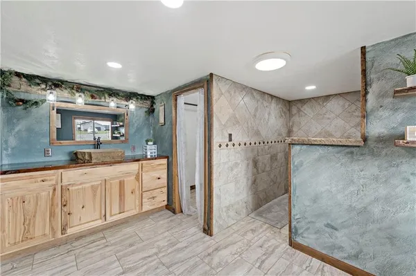 a spacious bathroom with a shower sink and mirror