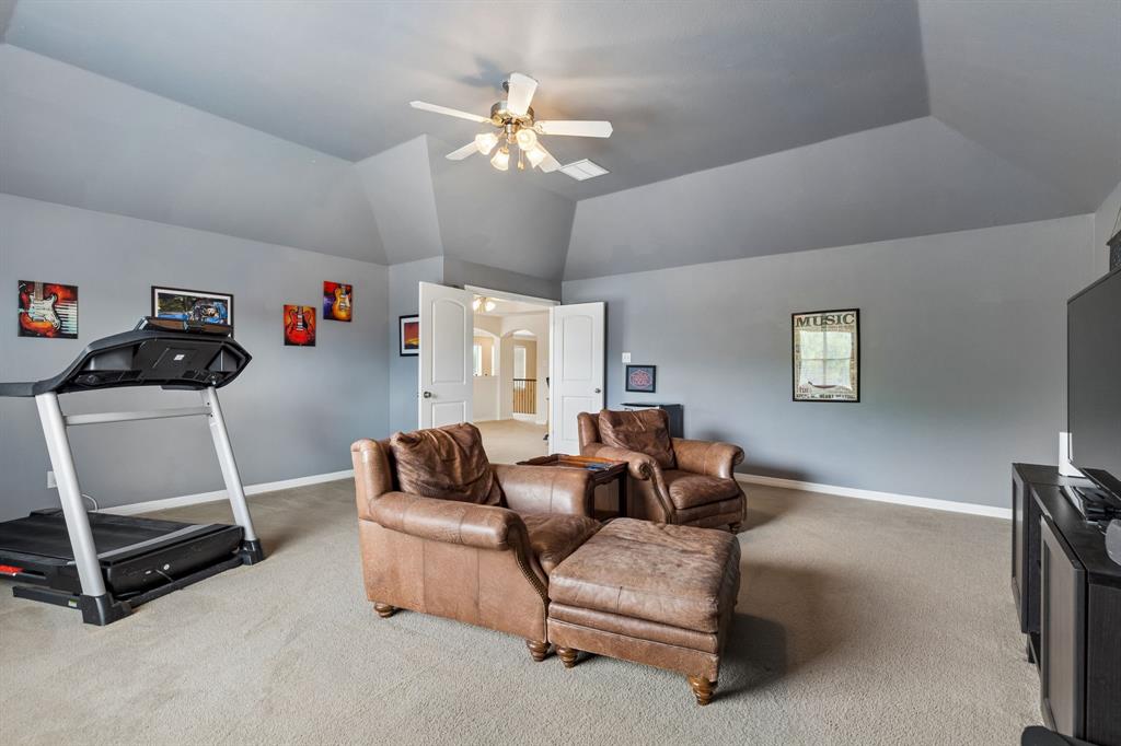 960 Remuda Road Frisco, TX 75033 - Photo 24 of 39 Spacious room featuring vaulted ceilings, a ceiling fan, carpeted flooring, and a large window providing natural light