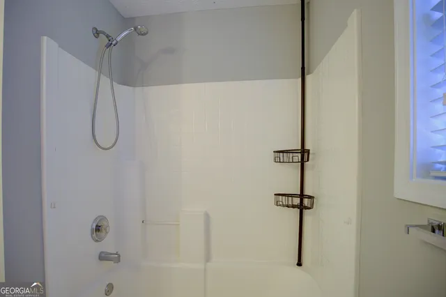 a bathroom with a bath tub with a shower