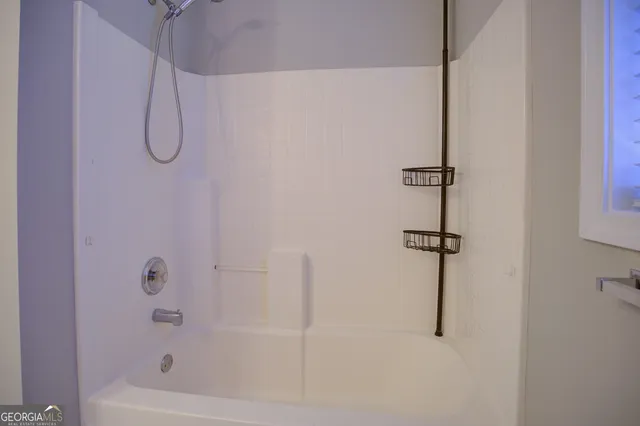a bathroom with a bath tub with a shower