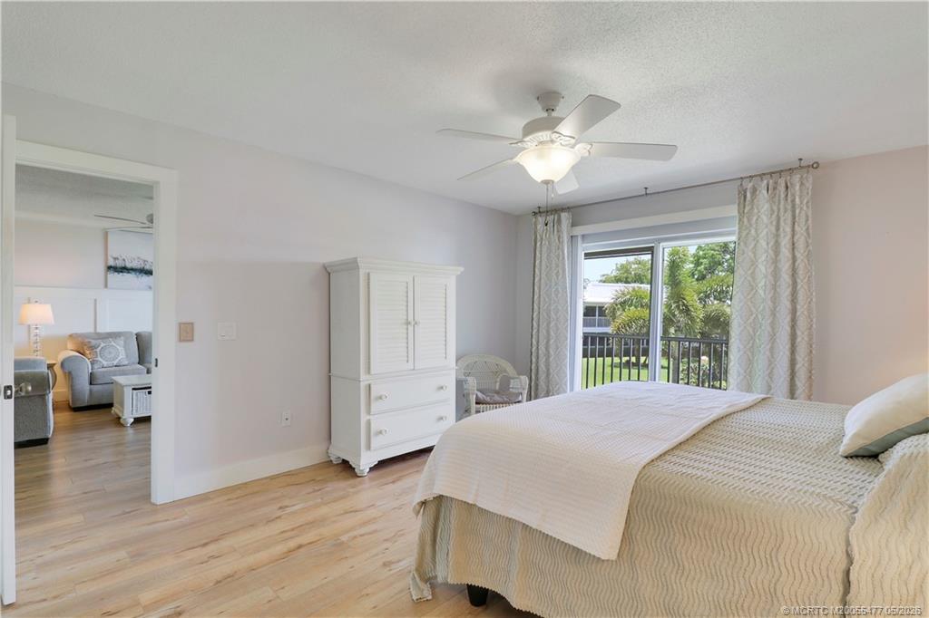 1852 Southwest Palm City Road, Unit 201 Stuart, FL 34994 - Photo 19 of 34 a bedroom with a large bed and a chandelier