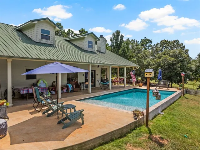 a view of a house with swimming pool and sitting area