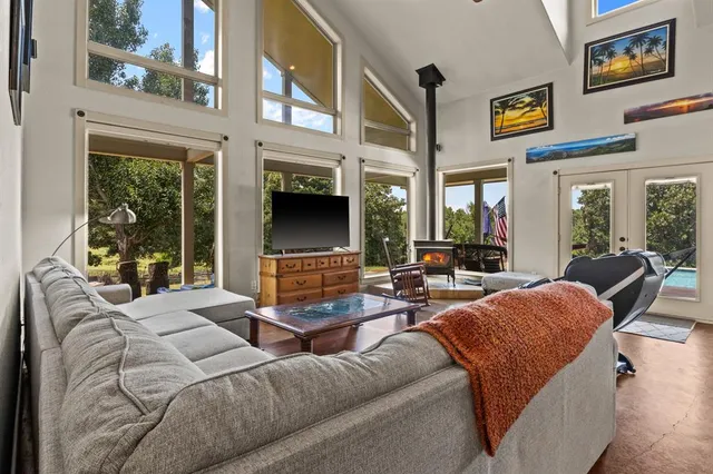 a living room with furniture fireplace and large windows