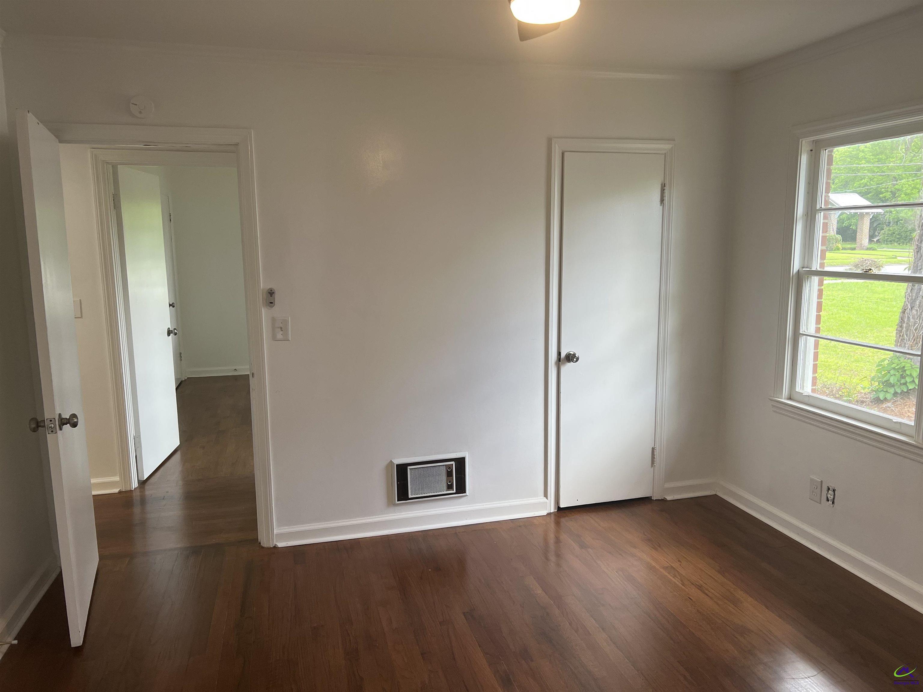 145 South 2nd Street Cochran, GA 31014 - Photo 19 of 24 an empty room with wooden floor and windows