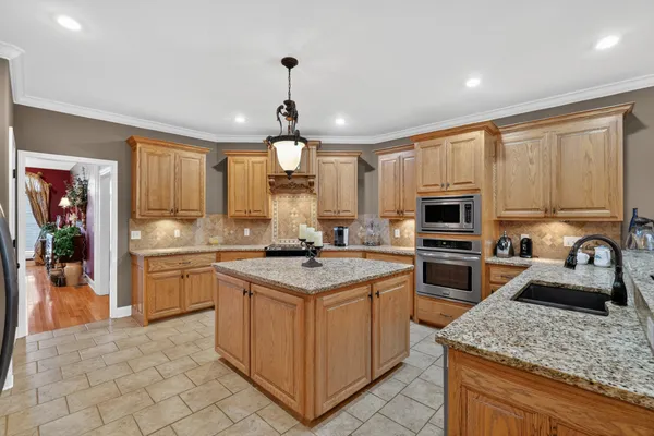 a kitchen with stainless steel appliances granite countertop white cabinets a sink stove and a refrigerator